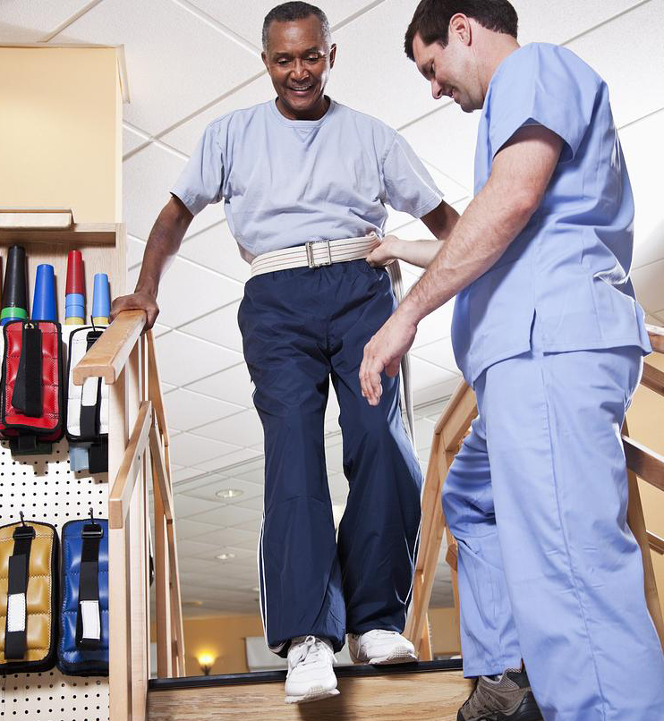 Physical therapist with senior man climbing stairs
